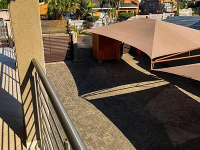 a umbrella on a sidewalk next to a building at Tshamani self catering in Hazyview