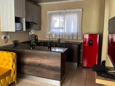 a kitchen with a red refrigerator in a room at Tshamani self catering in Hazyview