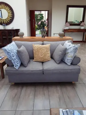 a gray couch with pillows in a living room at Cozy Coleman in Hartbeespoort