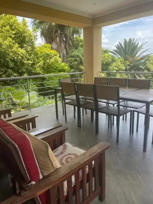 a balcony with benches and a table and a view at Cozy Coleman in Hartbeespoort