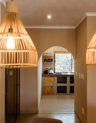 a kitchen with two pendant lights and a hallway at Jackals Dream - Self Catering Villa bordering Kruger National Park in Marloth Park