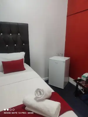 a hotel room with a bed with a red pillow at The Croc Guest house in Springs