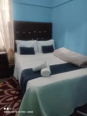 a bedroom with a large bed with white sheets and pillows at The Croc Guest house in Springs