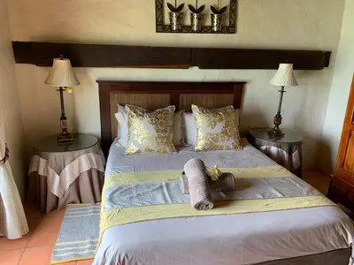 a bedroom with a bed with a teddy bear on it at Glen Aden in Dullstroom