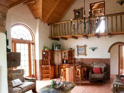 a living room with a chandelier hanging from the ceiling at Glen Aden in Dullstroom