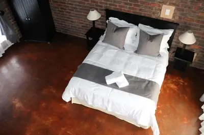 a bedroom with a large bed with white sheets and pillows at Sundowners Game Lodge in Marble Hall