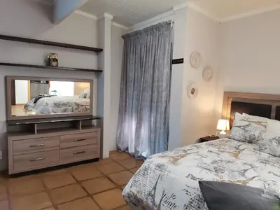 a bedroom with a bed and a television on a dresser at Mia Hills guest house in Hartbeespoort