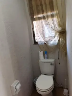 a small bathroom with a toilet and a window at Mia Hills guest house in Hartbeespoort