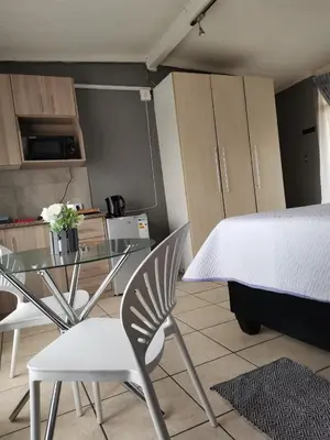 a kitchen with a glass table and a table and chairs at Mia Hills guest house in Hartbeespoort