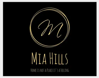 a gold m and n logo on a black background at Mia Hills guest house in Hartbeespoort