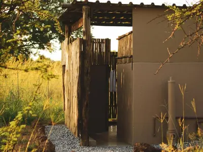 a wooden gate to a building with a fence at The Leadwood Safari Camp in Dinokeng Game Reserve