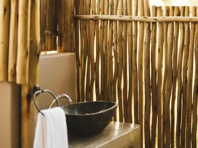 a black bowl on a table next to a wooden wall at The Leadwood Safari Camp in Dinokeng Game Reserve