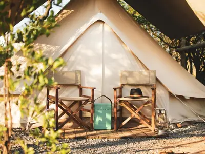 a person sitting in a chair in a tent at The Leadwood Safari Camp in Dinokeng Game Reserve