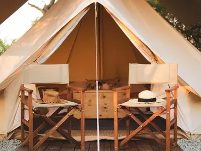 two chairs and a table in a tent at The Leadwood Safari Camp in Dinokeng Game Reserve