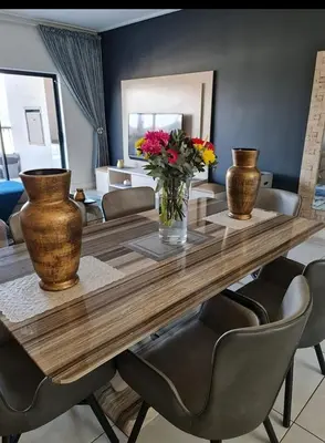 a dining room table with vases and flowers on it at Le Bon Dieu in Midrand