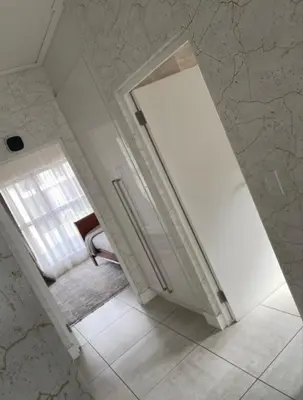 a white bathroom with a window and a sink at Le Bon Dieu in Midrand