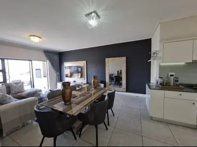 a kitchen and a living room with a table and chairs at Le Bon Dieu in Midrand