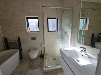 a bathroom with a sink and a shower and a toilet at Le Bon Dieu in Midrand