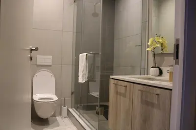 a bathroom with a toilet and a sink and a shower at Comfort at 1503 Menlyn Maine Residences in Pretoria