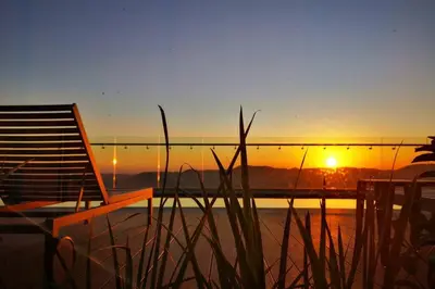 a chair sitting on top of a beach at sunset at Comfort at 1503 Menlyn Maine Residences in Pretoria