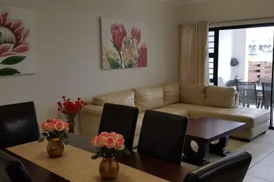 a living room with a couch and a table and chairs at Blyde 3 bed Lagoon View Apartment in Pretoria