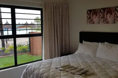 a bedroom with a bed and a large window at Blyde 3 bed Lagoon View Apartment in Pretoria
