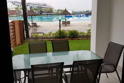 a glass table and chairs with a view of a pool at Blyde 3 bed Lagoon View Apartment in Pretoria