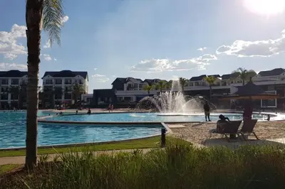 a person sitting in a chair next to a pool with a fountain at Blyde 3 bed Lagoon View Apartment in Pretoria