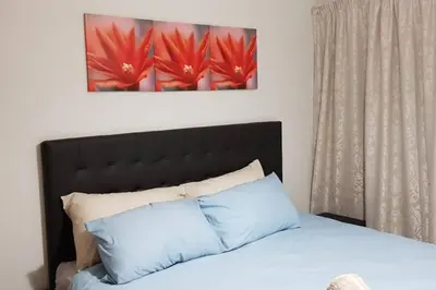 a bedroom with a bed with a picture on the wall at Blyde 3 bed Lagoon View Apartment in Pretoria