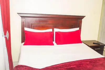 a bedroom with a bed with two red pillows at @431 Rupert Street in Pretoria