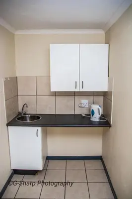 a small kitchen with white cabinets and a sink at @431 Rupert Street in Pretoria