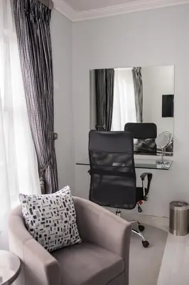 a living room with a couch and a chair and a mirror at Augusta Palms in Centurion