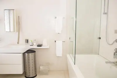 a white bathroom with a sink and a shower at Augusta Palms in Centurion