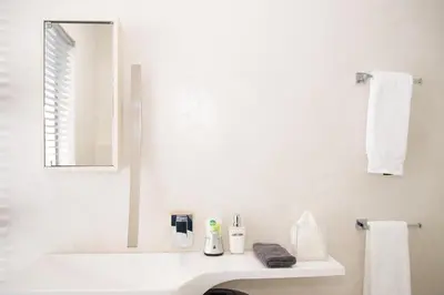 a white bathroom with a sink and a mirror at Augusta Palms in Centurion