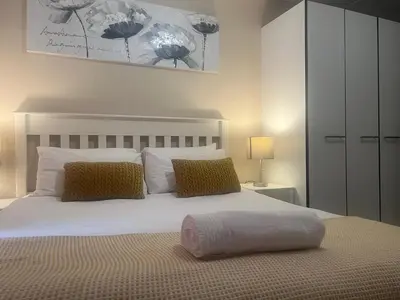 a bedroom with a large white bed with two pillows at Smart and Cozy Studio with Netflix and Showmax in Pretoria