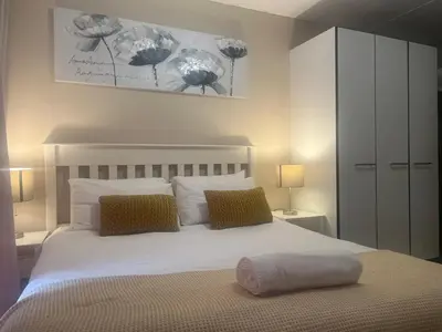 a bedroom with a large white bed with two pillows at Smart and Cozy Studio with Netflix and Showmax in Pretoria
