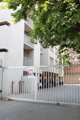 a white fence in front of a building at Smart and Cozy Studio with Netflix and Showmax in Pretoria