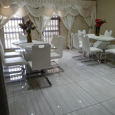 a dining room with white tables and white chairs at ANGELOCEAN GUEST HOUSE in Witbank