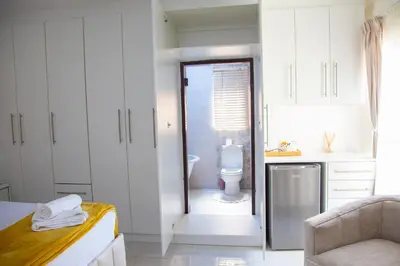 a white bathroom with a toilet and a sink at ANGELOCEAN GUEST HOUSE in Witbank