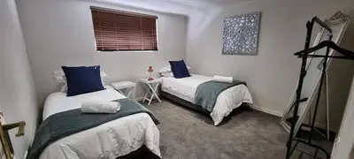 a bedroom with two beds with blue pillows at DullVino First House in Dullstroom