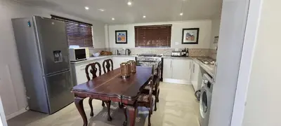 a kitchen with a wooden table and a refrigerator at DullVino First House in Dullstroom
