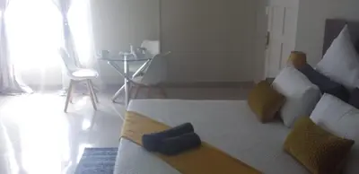 a bedroom with a large bed with a blue object on it at The Hide On Claremont in Pretoria