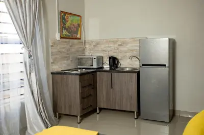 a kitchen with a refrigerator and a microwave at The Hide On Claremont in Pretoria
