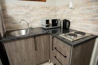 a kitchen counter with a sink and a microwave at The Hide On Claremont in Pretoria