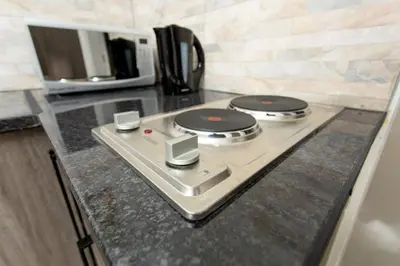 a kitchen counter with a stove with a microwave at The Hide On Claremont in Pretoria