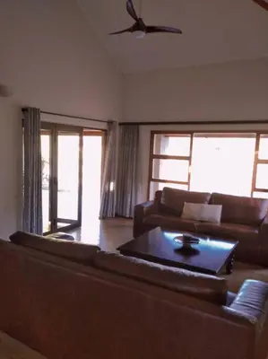 a living room with a couch and a table at Pecanwood Golf Estate Home - Hartbeespoort in Hartbeespoort