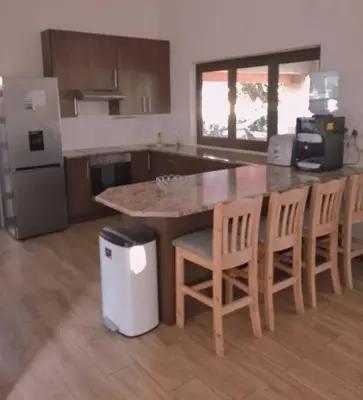a kitchen with a large island with chairs and a counter at Pecanwood Golf Estate Home - Hartbeespoort in Hartbeespoort