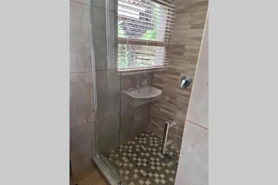 a bathroom with a shower and a sink at Pecanwood Golf Estate Home - Hartbeespoort in Hartbeespoort