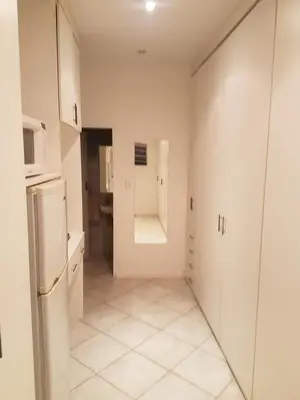a kitchen with white cabinets and a refrigerator at Roosboompies Guest Suite in Centurion