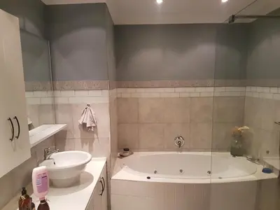 a bathroom with a bath tub and a sink at Roosboompies Guest Suite in Centurion